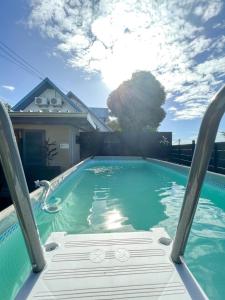 una piscina con una sedia di fronte a una casa di L'Eden - Villa cosy à Sainte-Clotilde a Sainte-Clotilde