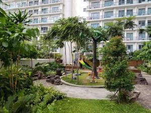a park in front of a building with a playground at Aveline Suites Cozy Skyline View ACQUA Private Residences near Rockwell Makati in Manila