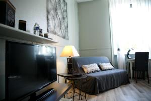 een woonkamer met een bank en een flatscreen-tv bij Logis Auberge De L'ombrée in Combrée