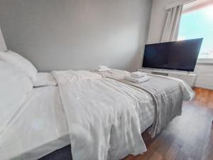 a bedroom with a bed and a flat screen tv at Residential Homes Franzén in Helsinki