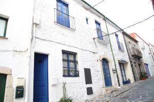 a white building with a blue door on a street at Apartament - COMPARTIR in Cadaqués