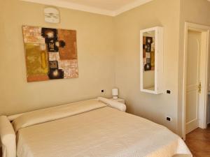 a bedroom with a bed and a painting on the wall at La chicca del porto in Santa Teresa Gallura