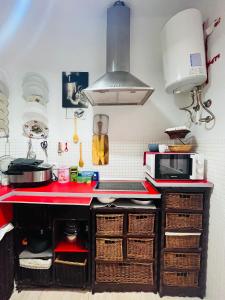 cocina con encimera roja con cestas en Apartamento Privado en Alameda de Hércules, en Sevilla