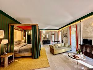 a bedroom with a bed and a couch and a table at Chateau des Arpentis in Amboise