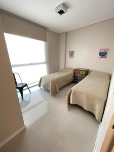 1 dormitorio con 2 camas y ventana en Depto. a Estrenar, Terraza Vista al Mar en Puerto Madryn
