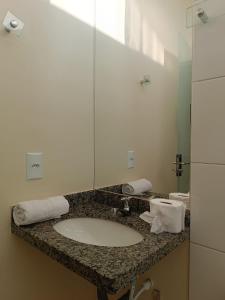 a bathroom counter with a sink and a mirror at Pousada Águas do Jalapão in Ponte Alta do Norte