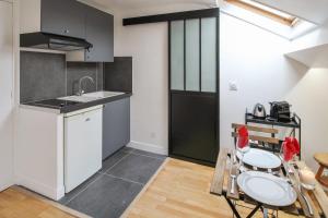 a kitchen with a sink and a table and chairs at Charming studio 3 min away from Château de Versailles - Welkeys in Versailles