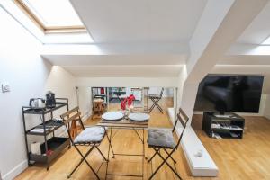 a living room with a table and chairs at Charming studio 3 min away from Château de Versailles - Welkeys in Versailles