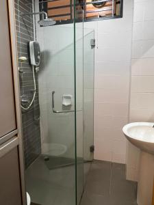a glass shower in a bathroom with a sink at 20 HoMESTAY COZY STUDIO MOUNT AUSTIN TEBRAU NEAR JUSCO TOPPEN in Johor Bahru