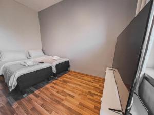 a small room with a bed and a television at Residential Homes Franzén in Helsinki