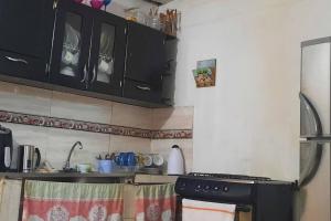 uma cozinha com armários pretos e um fogão em Apartamento Cómodo en Medellín em Bello