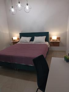 a bedroom with a bed with a purple blanket and a chair at Vita vi in Afionas
