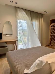 a bedroom with a bed and a large window at Aerin Residence in Limenaria