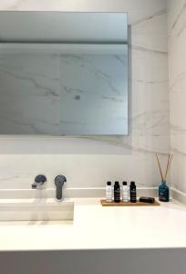 a bathroom counter with a sink and a mirror at Aerin Residence in Limenaria