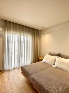 a bedroom with a large bed and a large window at Aerin Residence in Limenaria +7 photos