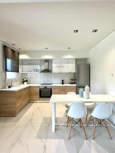 a kitchen with a white table and two chairs at Aerin Residence in Limenaria