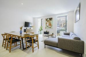 a living room with a couch and a dining room table at The White Flats Sant Antoni in Barcelona