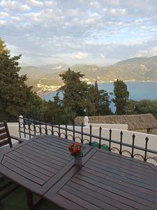 einen Holztisch mit einer Vase aus Blumen auf dem Balkon in der Unterkunft Vita vi in Afionas