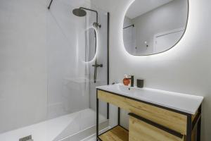 a bathroom with a white sink and a mirror at The White Flats Sant Antoni in Barcelona +81 photos