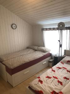 ein Schlafzimmer mit einem Bett mit roten Blumen darauf in der Unterkunft Almenningsgata 9A in Stavanger