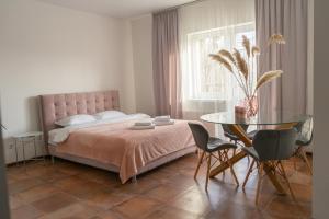 文尼察TREND HOUSE Apartments的带床和玻璃桌的卧室