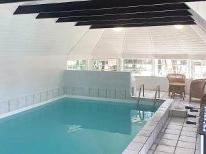 a swimming pool with blue water in a house at Six-Bedroom Holiday home in Væggerløse 3 in Marielyst