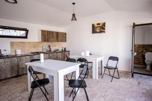 a kitchen with two tables and chairs in a room at complex turistic N&S in 2 Mai
