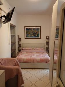 1 dormitorio con 1 cama y TV. en appartamento Aurora, en Giulianova