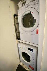 uma máquina de lavar roupa e uma máquina de lavar roupa num quarto em Spacious comfortable & private parking in town centre em Cheltenham