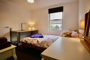 a small bedroom with a bed and a window at Spacious comfortable & private parking in town centre in Cheltenham