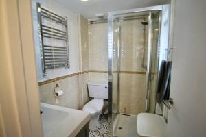 La salle de bains est pourvue de toilettes, d'un lavabo et d'une douche. dans l'établissement Spacious comfortable & private parking in town centre, à Cheltenham