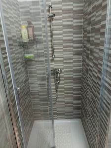 La salle de bains est pourvue d'une douche avec une porte en verre. dans l'établissement appartamento Aurora, à Giulianova