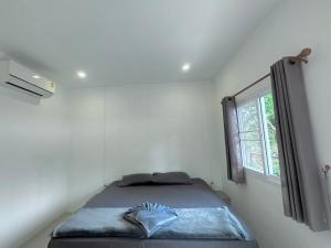 a bed in a room with a window at Live In Leaf Koh Tao in Koh Tao