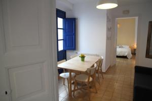 a dining room with a table and chairs and a bedroom at Apartament - COMPARTIR in Cadaqués