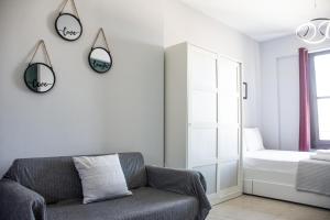 un soggiorno con divano e specchi sul muro di SKG Premium Studios Kastra a Salonicco