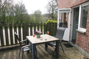 a table and two chairs on a patio at Gulpdal Vakantiewoningen. in Gulpen