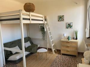 salon z łóżkiem piętrowym i krzesłem w obiekcie charmant studio Avignon intra muros w Awinionie