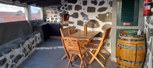 a wooden table and chairs on a patio at AL - Adega do Terra in Madalena