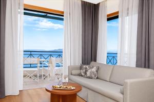 uma sala de estar com um sofá e uma mesa em Ramada by Wyndham , Athens Club Attica Riviera em Mati