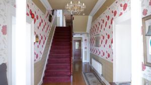 a staircase in a home with red and white walls at Kilmurvey House in Kilronan