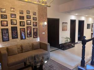 a living room with a couch and pictures on the wall at Shelton Hotel in Rawalpindi