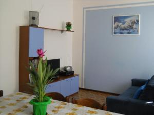 - un salon avec une table et un canapé bleu dans l'établissement Appartamento Al Ponte, à Marone