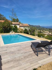 a swimming pool with a table and a chair next to it at La Tourrette in Tourrettes-sur-Loup