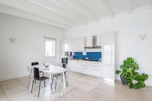 a white kitchen with a white table and chairs at Padova Albignasego Apartment con terrazzo x7! in Albignasego