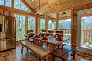 a dining room with a table and a refrigerator at Rocky Top Lookout, 4 BR, Theater, Arcade, Bumper Pool, Hot Tub, Sleeps 12 in Gatlinburg