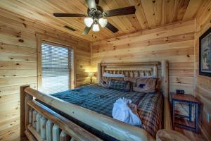 a bedroom with a bed in a log cabin at Rocky Top Lookout, 4 BR, Theater, Arcade, Bumper Pool, Hot Tub, Sleeps 12 in Gatlinburg
