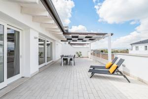 patio con banco y mesas en el balcón en Padova Albignasego Apartment con terrazzo x7!, en Albignasego