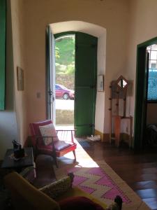 a living room with a chair and an open door at Casa de João in Ouro Preto