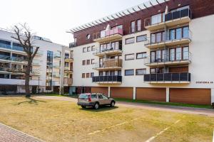 a car parked in a parking lot in front of a building at Duży Apartament w Helskiej Villi in Hel