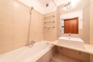een badkamer met een wastafel en een bad bij Duży Apartament w Helskiej Villi in Hel